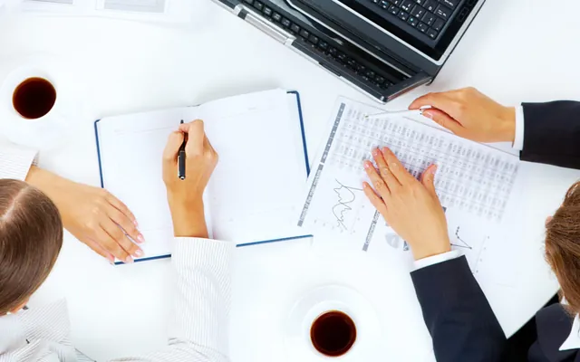 Hand writing project notes in a planner